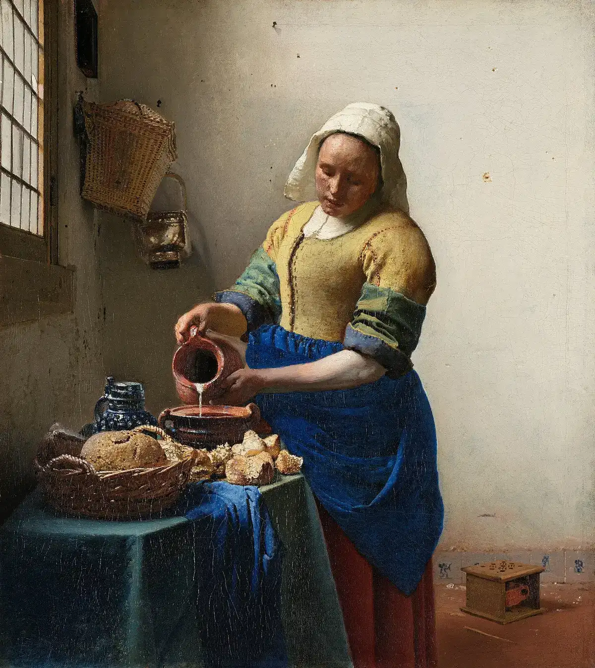 Vermeer's The Milkmaid: a servant pouring milk from a jug at a table by a window.