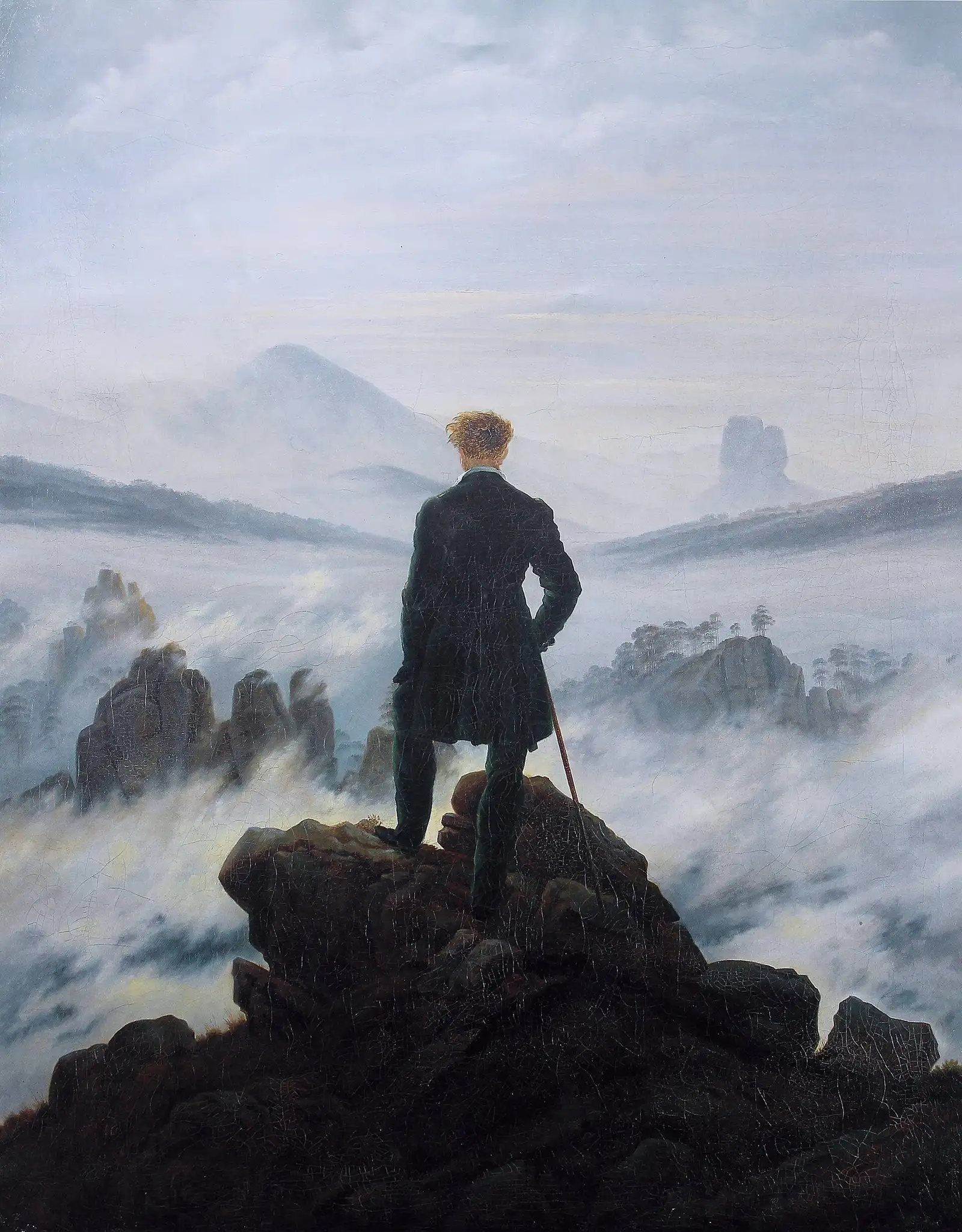 Friedrich's Wanderer above the Sea of Fog: a man on a rock outcrop looking over cloud-filled peaks.